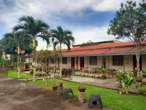 锡朗米妮旅馆的一座前面有棕榈树的建筑