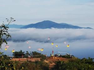 a bunch of kites flying in the sky over a mountain at Azizan Homestay Bahau in Bahau