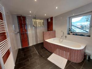 Appartement WiSo في ماوترندورف: حمام مع حوض استحمام ونافذة