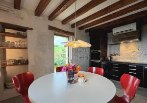 ディゴワンにあるLa Colline Digoinのキッチン(白いテーブル、赤い椅子付)