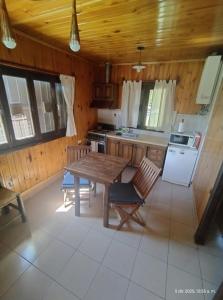 a kitchen with a table and chairs in a room at Cabañas Viña Aliwen in Vistalba
