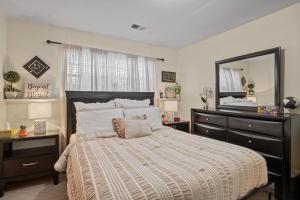 a bedroom with a bed with a dresser and a mirror at Fireplace • Grill • Gym‑Ready • Near Bull Run in Centreville