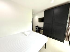 1 dormitorio con cama blanca y armario negro en Easy Life R2, en Patong Beach 3 fotos más