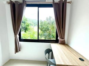 Habitación con mesa de madera y ventana. en Easy Life R2, en Patong Beach