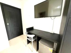 Un escritorio negro con un televisor en la pared. en Easy Life R2, en Patong Beach