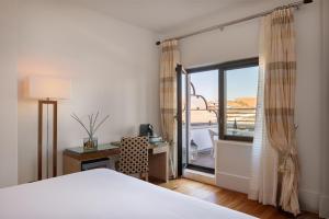 a bedroom with a bed and a desk and a window at UNA Hotels Decò Roma in Rome +36 photos