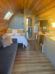 Mill House Farm Pods - Lapwing Lodge في Pilling: غرفة بسرير ومطبخ في كابينة