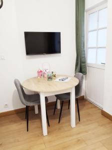 Et tv og/eller underholdning på Plein centre Cosy 38m2 avec accès terrasse, spa et sauna communs Place Dalton