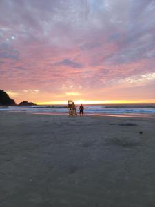 een persoon op een strand bij zonsondergang bij Rede Bem Te Vi - Itaguá in Ubatuba