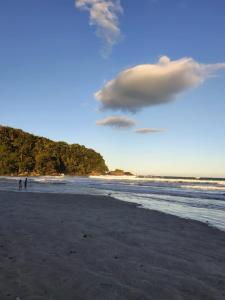 een paar mensen die op het strand lopen bij Rede Bem Te Vi - Itaguá in Ubatuba