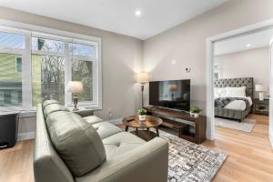 a living room with a couch and a tv and a bed at Luxury 2BR near Cabmridge in Somerville