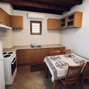 Una cocina con una mesa con sillas y una estufa. en Complex Ristanite, en Elena