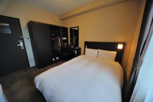 a bedroom with a large white bed in it at Dormy Inn Express Koriyama in Koriyama