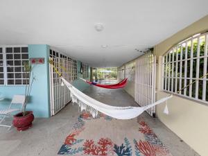 a hammock in the hallway of a house at Tropical Naguabo Beach House Pool n Beach in Naguabo