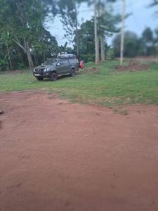 a car parked on the side of a dirt road at Risa Camping Site in Kiyunga