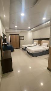 a hotel room with two beds and a chair at فندق اجنحة السمو إن in Aḩad al Masāriḩah +29 photos