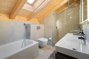 Un baño con bañera, inodoro y lavabo. en Visionary Hospitality Bassersdorf, Zürich - Premium Apartments in Swiss Style with Free Parking, Washer, Kitchen, Terrace, Vaulted Cellar Event Room, Bus Stop, 15' City & Airport, en Bassersdorf 99 fotos más