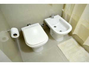 ein weißes Bad mit einem WC und einem Waschbecken in der Unterkunft Casa ivana 1 in Buenos Aires