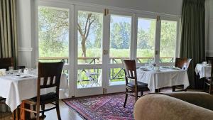 蒙塔古Montagu Vines Guesthouse的餐厅里有桌椅和窗户。