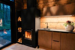 a kitchen with a fireplace in the corner of a room at Skýra Retreat in Rovaniemi