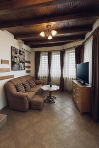 Una sala de estar con un sofá y un televisor. en Complex Ristanite, en Elena