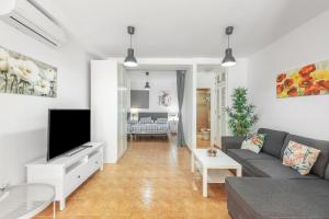 un soggiorno con un divano e una TV di Vv Caracola a Puerto de Mogán