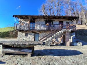 Il Rustico في Colleretto Castelnuovo: مبنى حجري به درج ومقعد