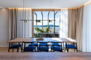 a dining room with a table and blue chairs at Villa Mare Zadar in Zadar