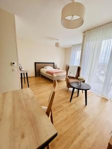 a living room with a table and a bed at Domitys Les Châtaigniers in Panazol