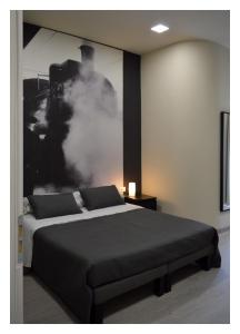 een slaapkamer met een bed en een foto aan de muur bij B&B Stazione Dittaino in Assoro