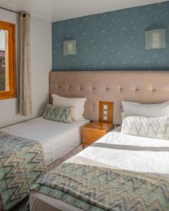 Un dormitorio con dos camas y una pared azul. en Elegant Family Chalet a Imi Ouaddar Comfort & Calm, en Agadir
