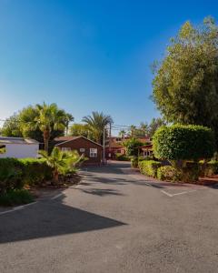 Elegant Family Chalet a Imi Ouaddar Comfort & Calm في أغادير: شارع مليء بالأشجار والمنازل في يوم مشمس