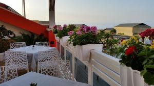 einen Balkon mit Blumen, Tischen und Stühlen in der Unterkunft Ciccolella B&B in Vibo Valentia Marina