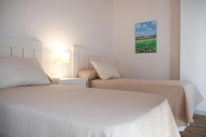 a bedroom with two beds and a painting on the wall at La Caseta del tío Antonio in El Parral