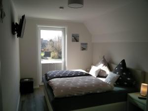 een bed in een kamer met een raam bij Ferienwohnung Harlezauber Carolinensiel in Carolinensiel