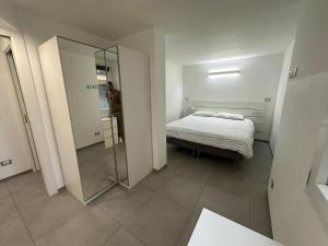 a man standing in a bedroom with a bed and a mirror at Sea House Superior in Pietra Ligure