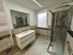 a white bathroom with a sink and a shower at Sea House Superior in Pietra Ligure