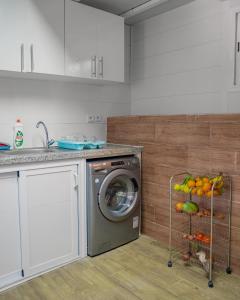 Elegant Family Chalet a Imi Ouaddar Comfort & Calm في أغادير: مطبخ مزود بغسالة ملابس وبعض الفاكهة