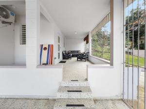 Un pasillo abierto con paredes blancas y grandes ventanales. en Casa Luquillo Cozy Retreat House With Pool n Tub, en Luquillo