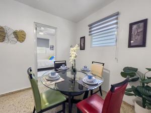 Un comedor con una mesa de cristal y sillas. en Casa Luquillo Cozy Retreat House With Pool n Tub, en Luquillo