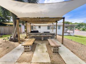 una pérgola con mesa de picnic y bancos en Casa Luquillo Cozy Retreat House With Pool n Tub, en Luquillo