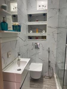 a white bathroom with a toilet and a sink at Apartment with piscine in Mansouria +11 photos