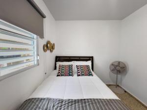 Un dormitorio con una cama con ventilador y una ventana. en Casa Luquillo Cozy Retreat House With Pool n Tub, en Luquillo