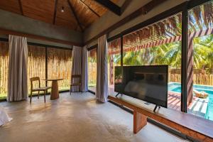 a living room with a large flat screen tv at Villas Taturé in São Miguel dos Milagres