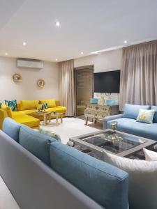 sala de estar con muebles de color azul y amarillo en Apartment with piscine, en Minaret de Mansuria