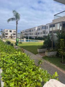 un parque con una palmera y un edificio en Apartment with piscine, en Minaret de Mansuria