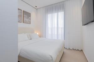 Una habitación blanca con una cama y una ventana en Melony Apartments Htmarim 22 Street, en Eilat