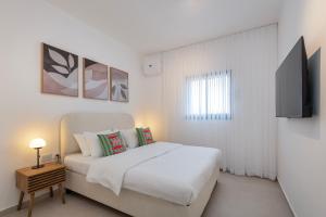 Un dormitorio blanco con una cama y un televisor. en Melony Apartments Htmarim 22 Street, en Eilat 2 fotos más