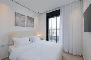 Un dormitorio con una cama blanca y una ventana grande. en Melony Apartments Htmarim 22 Street, en Eilat