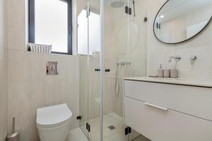 Un baño con ducha, inodoro y espejo. en Melony Apartments Htmarim 22 Street, en Eilat